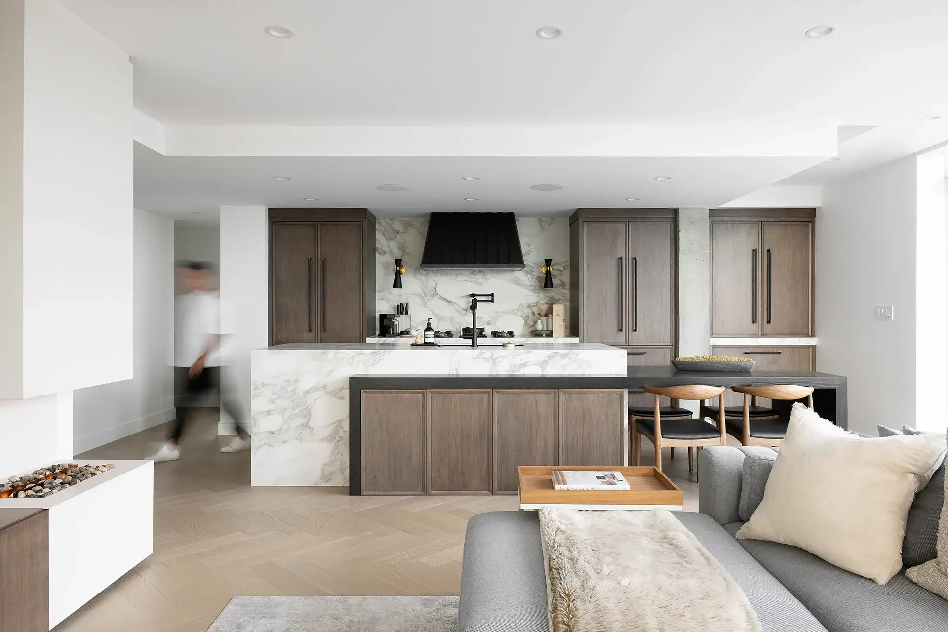 Large-format Infinity porcelain slabs on kitchen island, backsplash and waterfall edge in The Paddock residential project, British Columbia